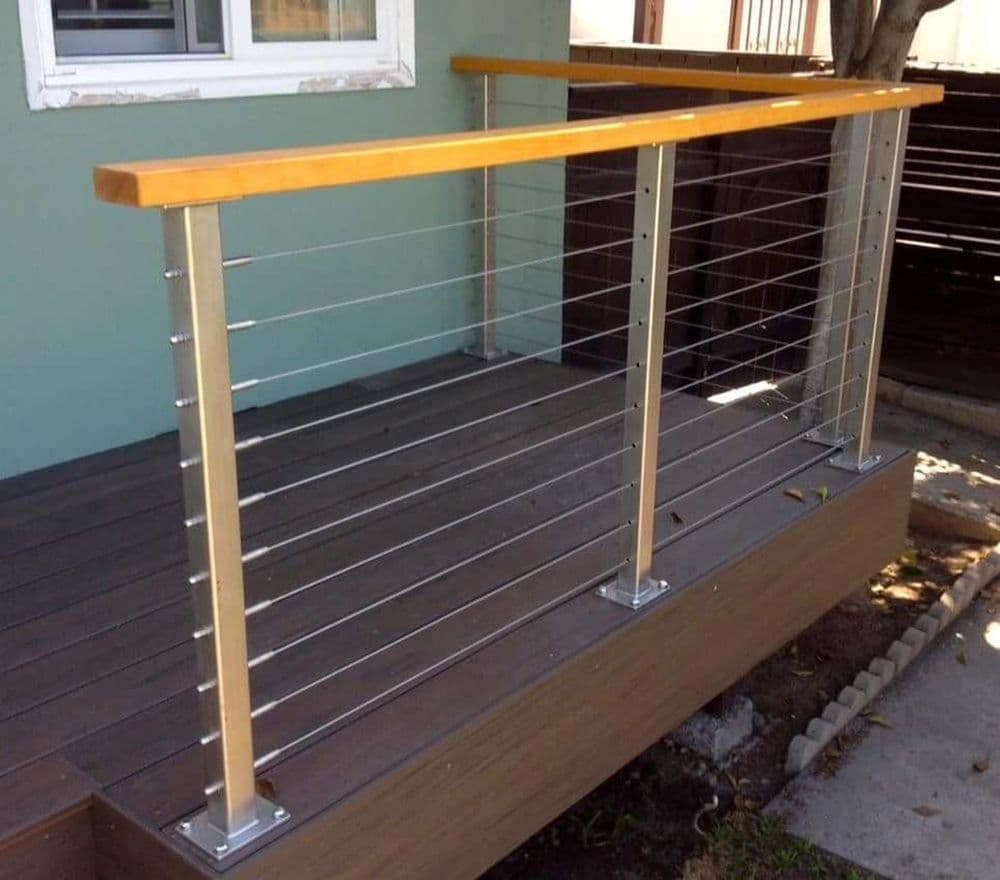 Modern wooden railing on a stylish deck with stainless steel cables for safety.