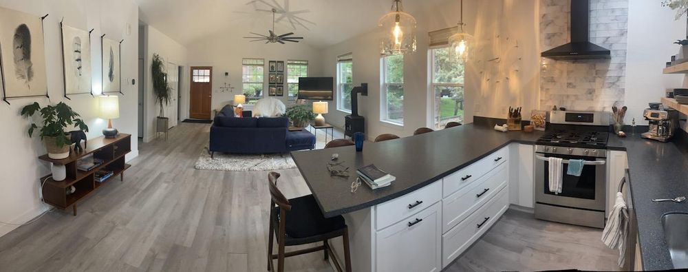 Modern open-concept living room and kitchen with stylish decor and ample natural light.