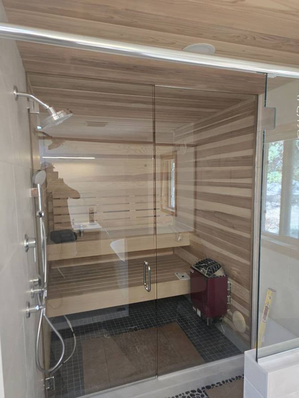 Modern bathroom shower with glass enclosure, wood-paneled walls, and stylish fixtures.